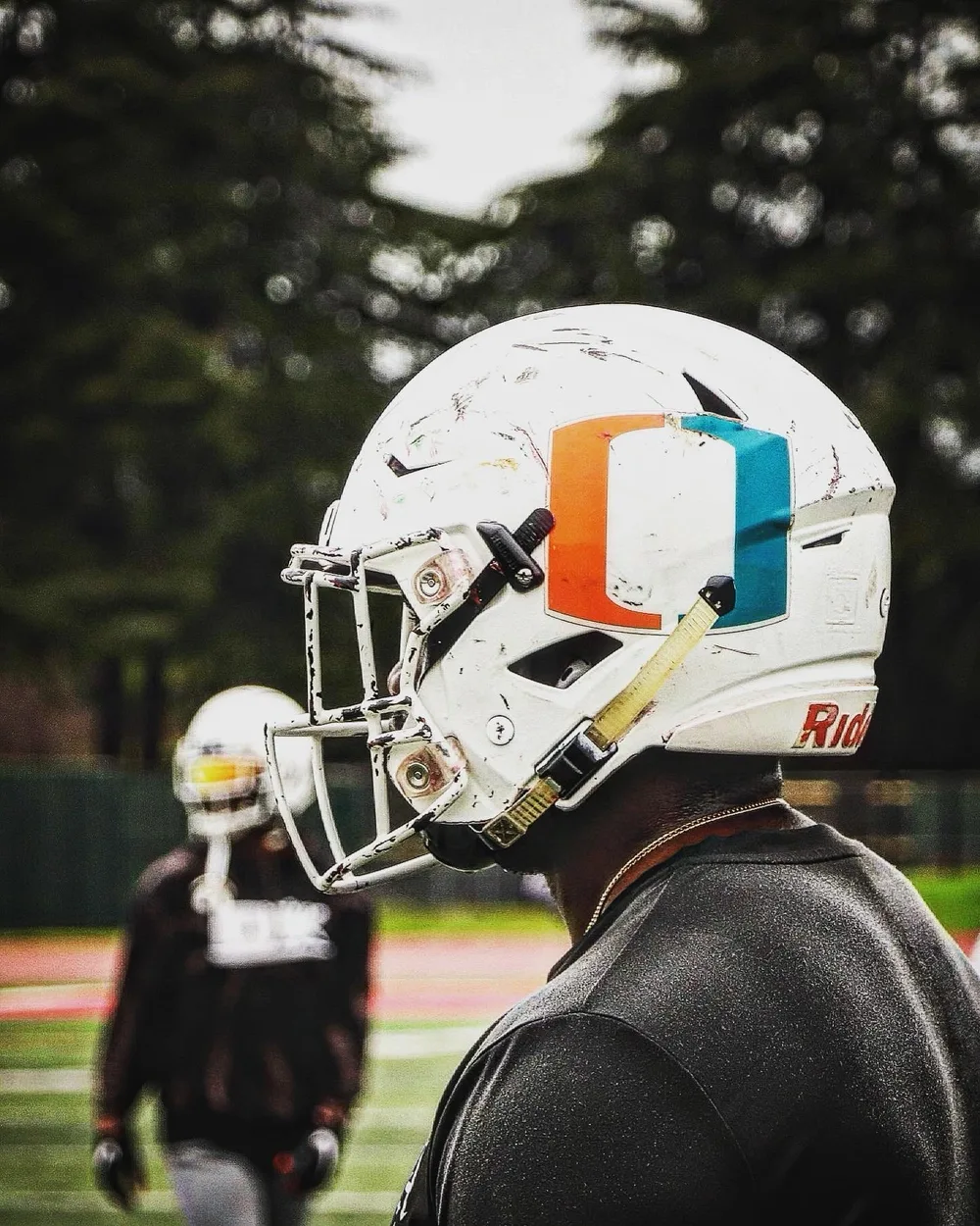 Ricky Flowers, founder of Built By Discipline Athletics, in a football helmet on the practice field